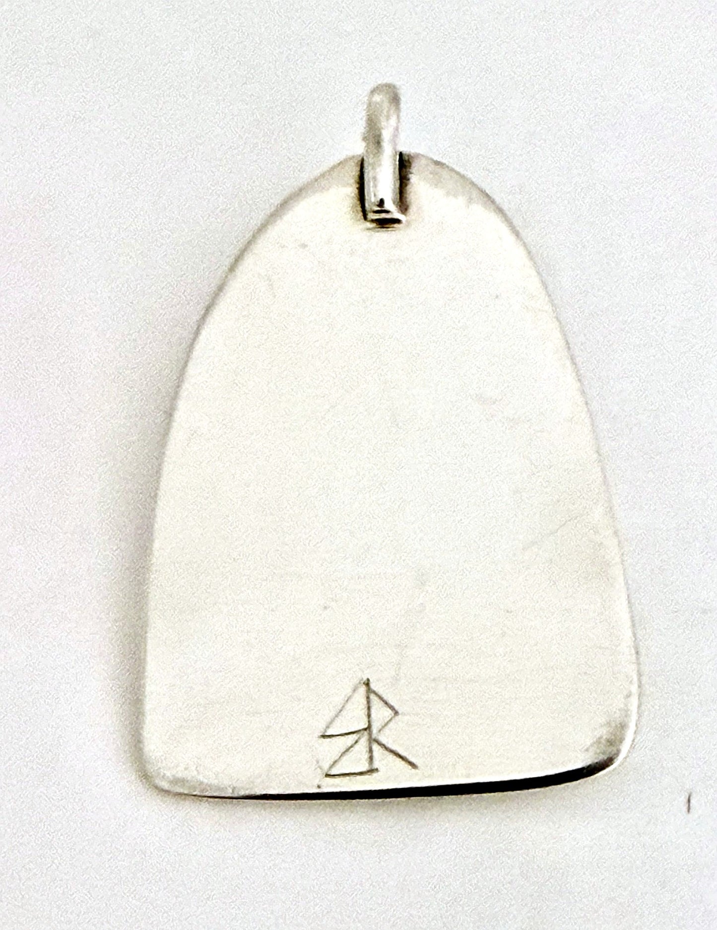 Hand-finished back of the sterling silver dinosaur pendant with maker's mark