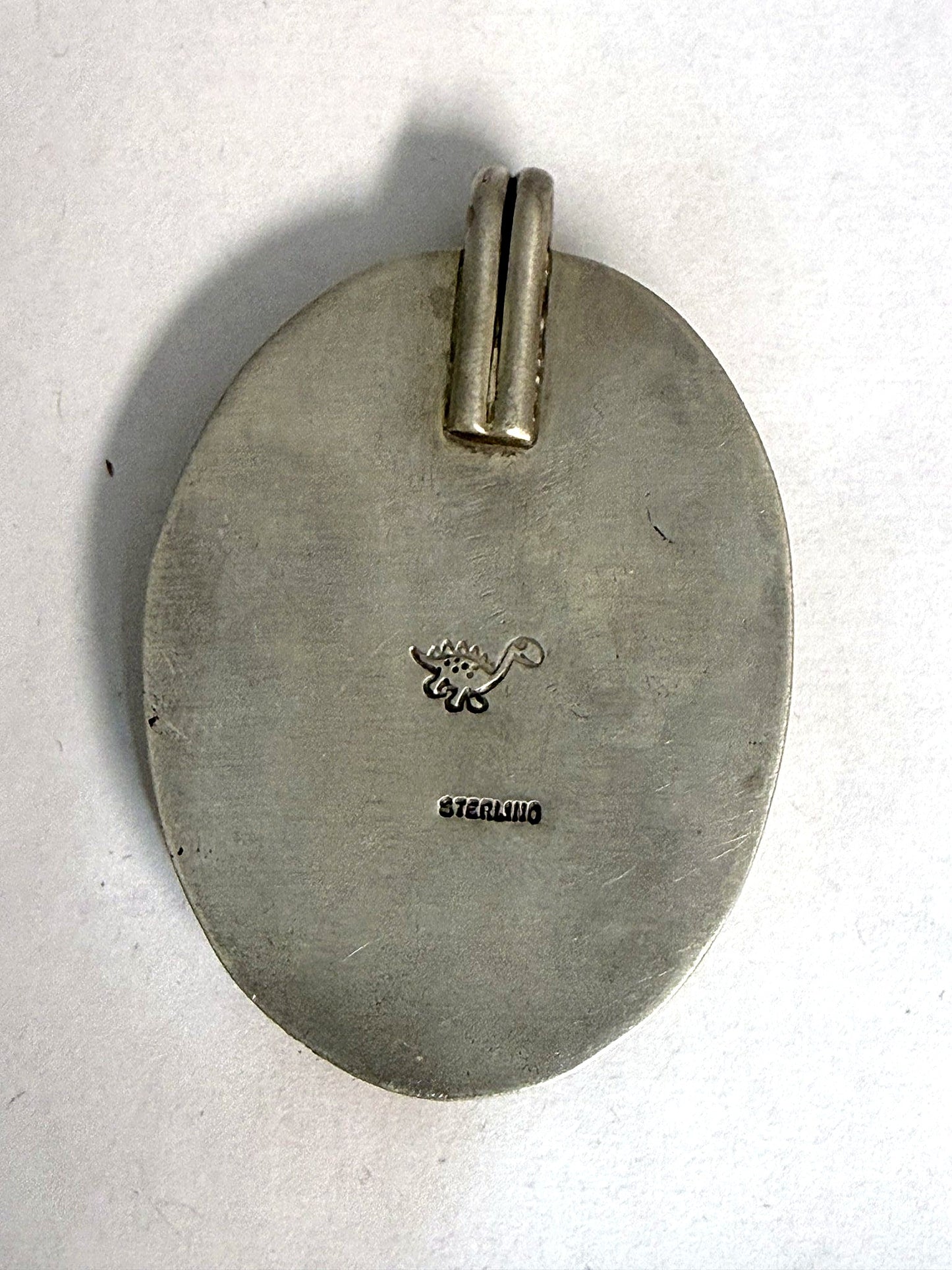Hand-finished back stamped STERLING with the dinosaur maker's mark