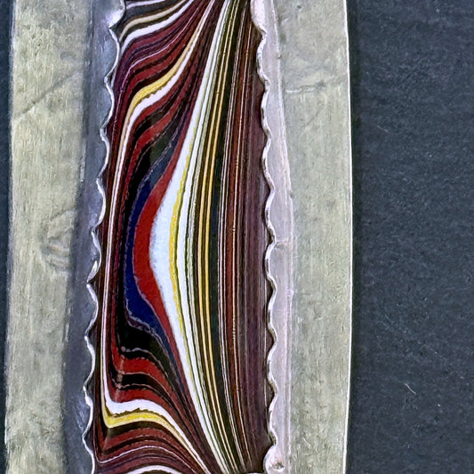 Macro of the Detroit-paint fordite layers in the pendant