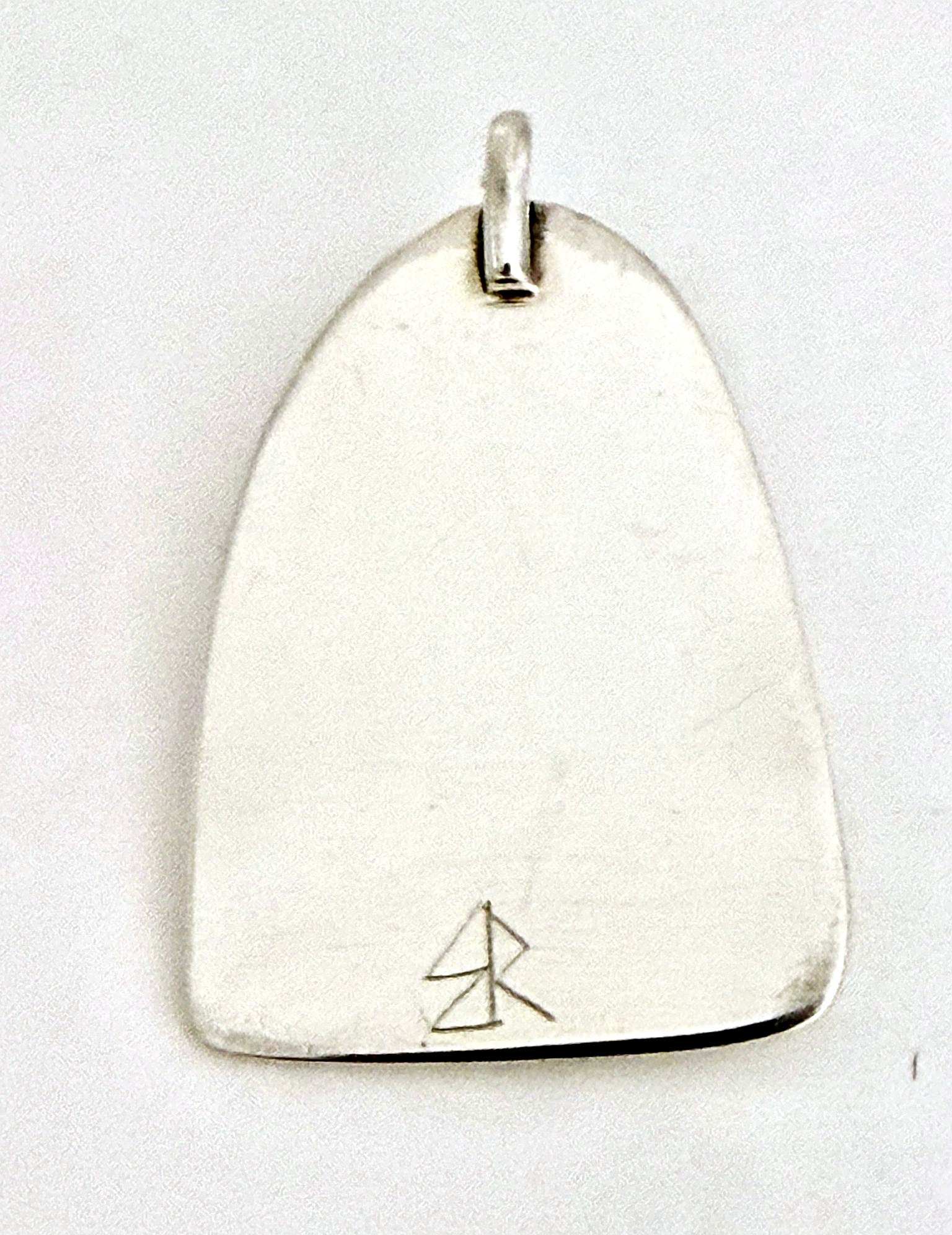 Hand-finished back of the sterling silver dinosaur pendant with maker's mark