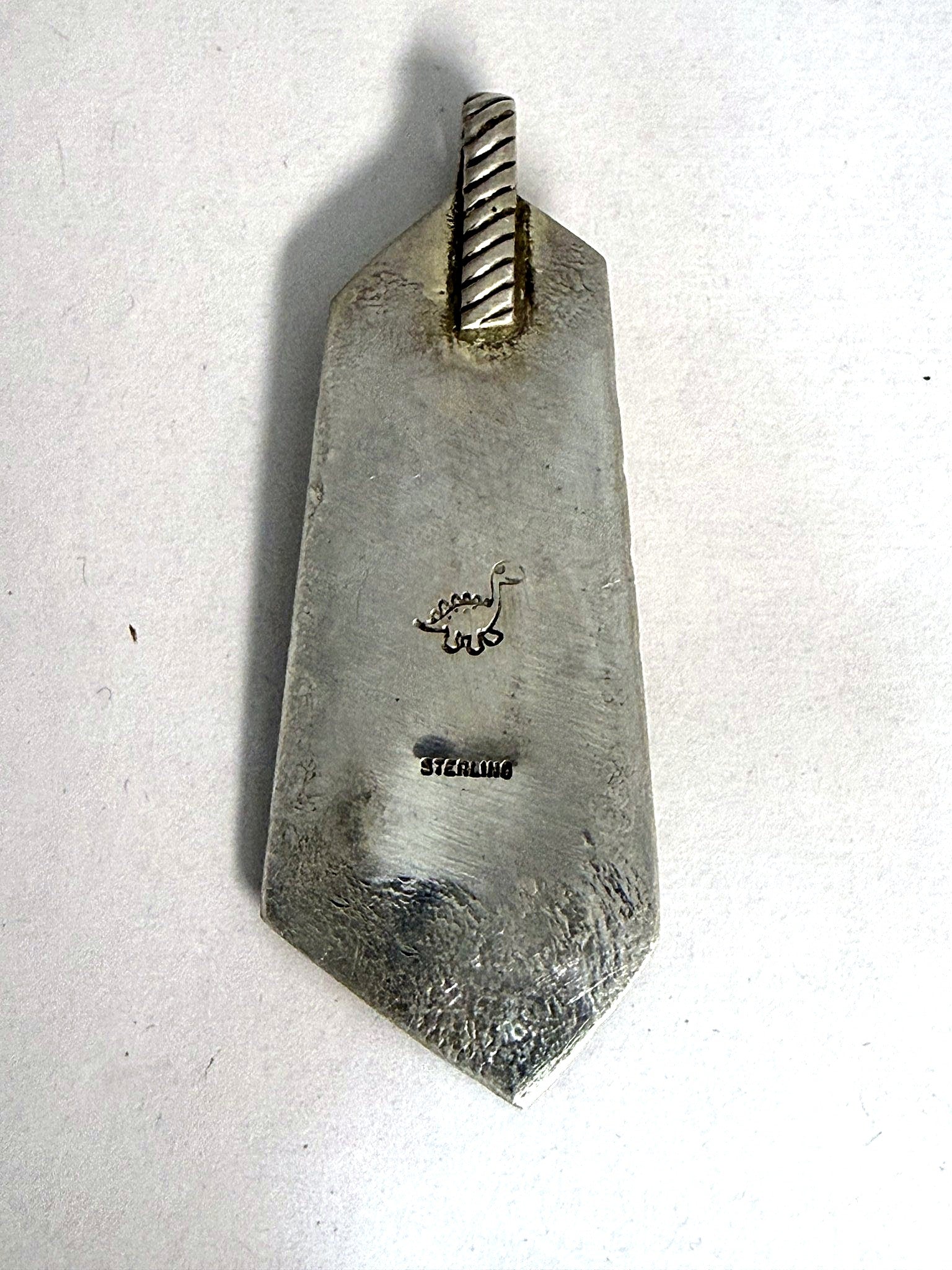 Hand-finished back stamped with the dinosaur maker's mark and STERLING
