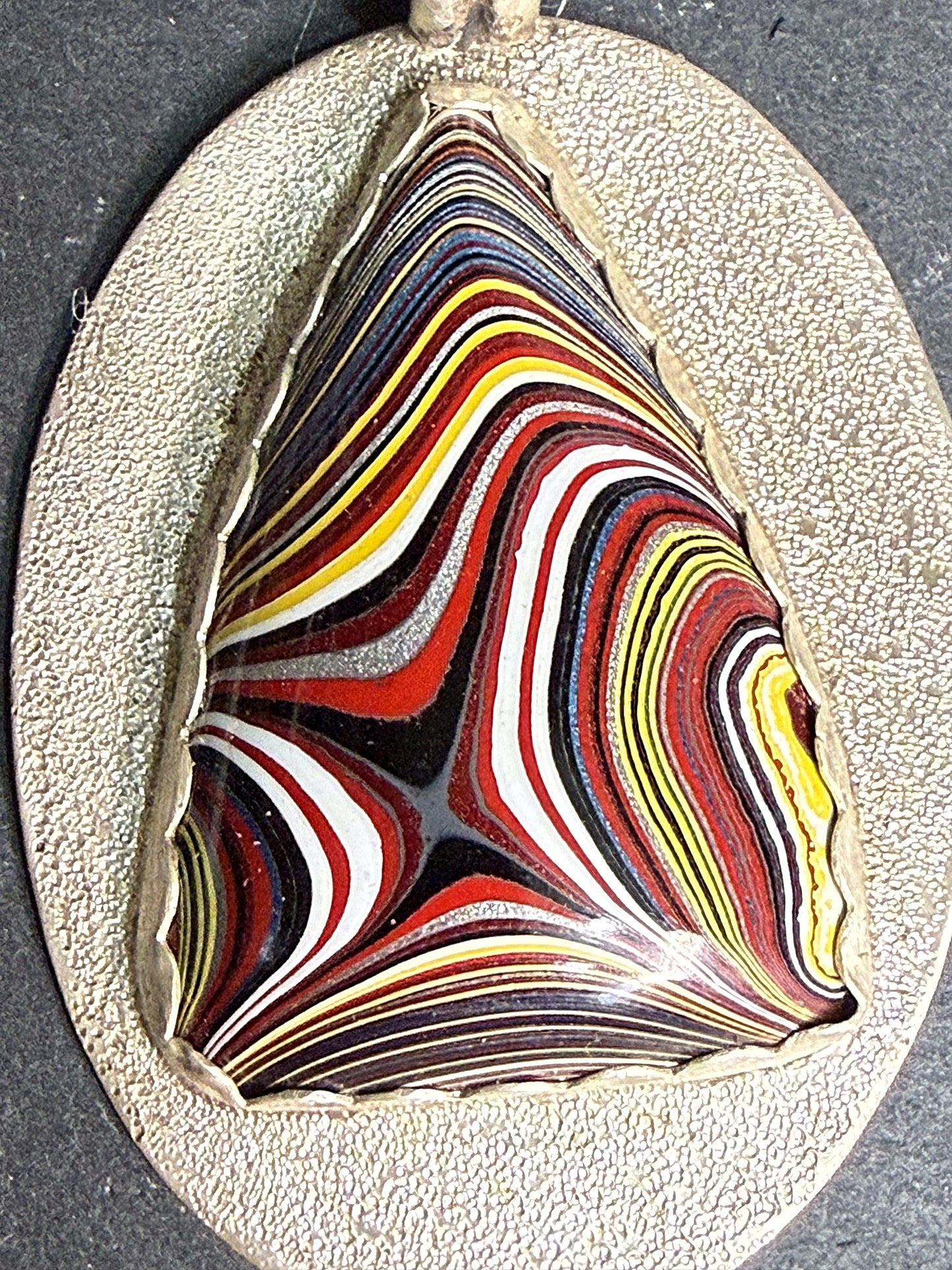 Macro detail of the swirling fordite cabochon