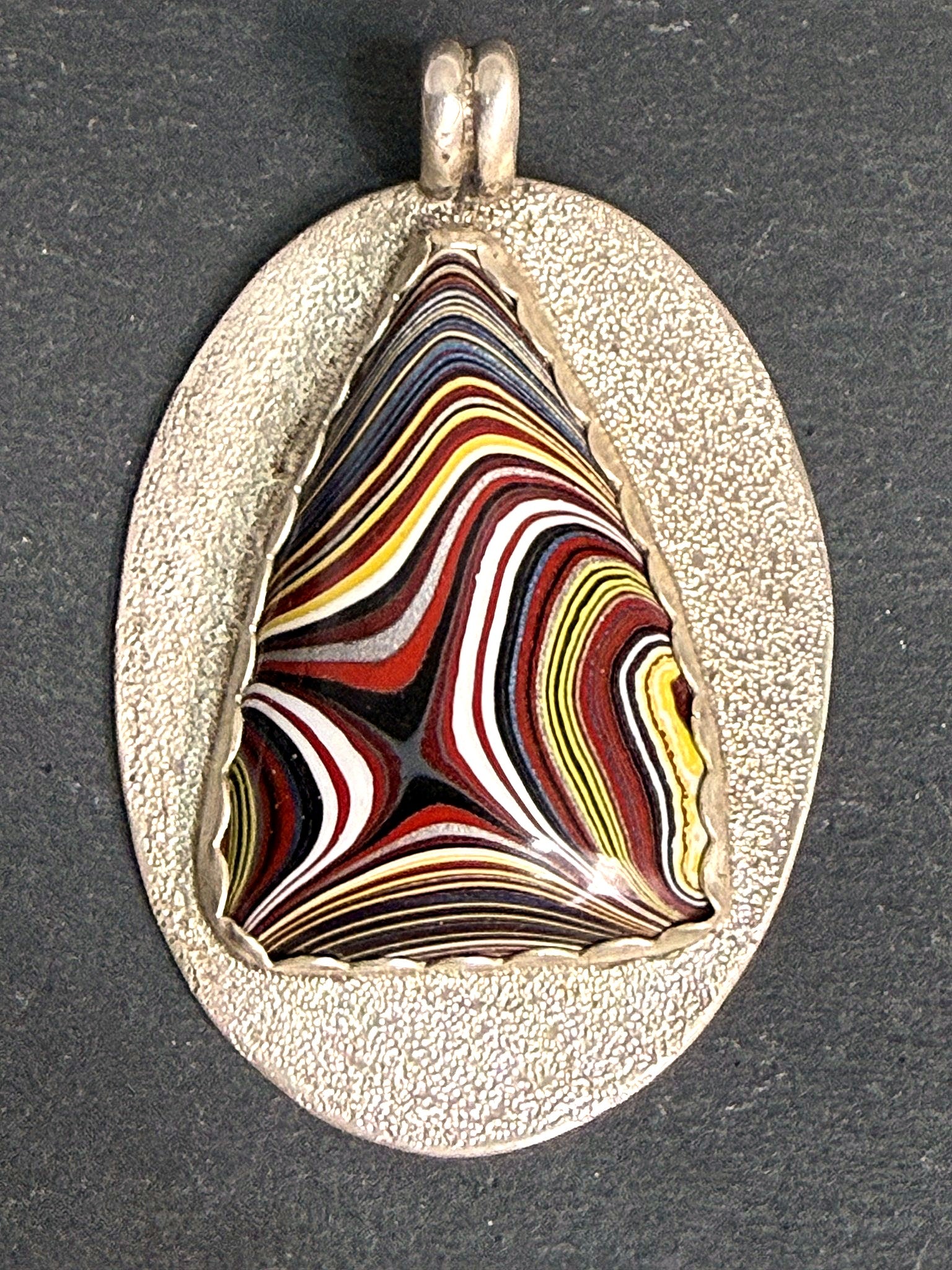 Fordite oval pendant styled on slate
