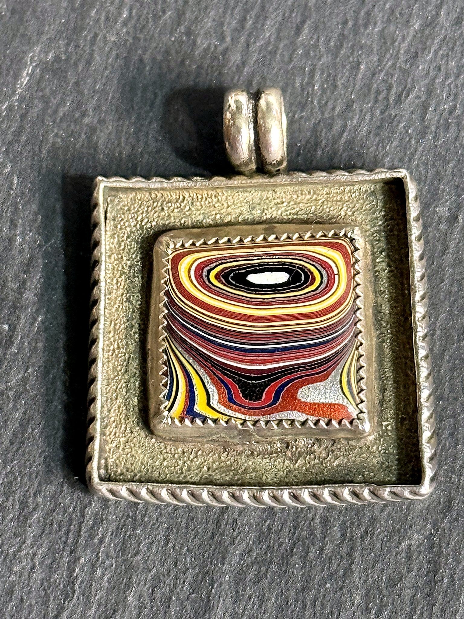 Fordite square pendant styled on slate