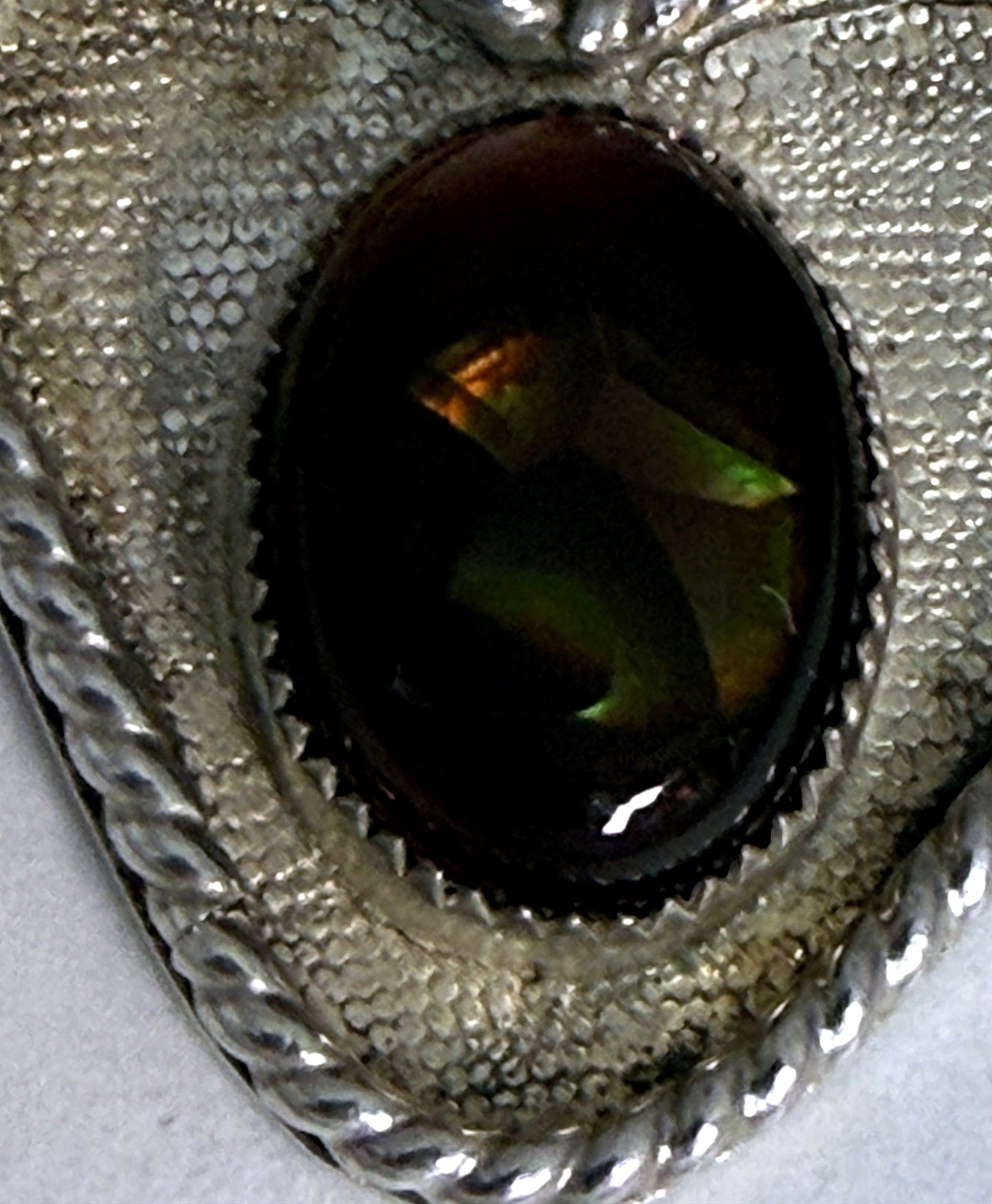 Macro of the fire agate cabochon showing flashes of green, gold and orange fire