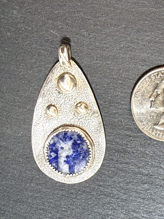 Lapis lazuli teardrop pendant shown beside a quarter for scale