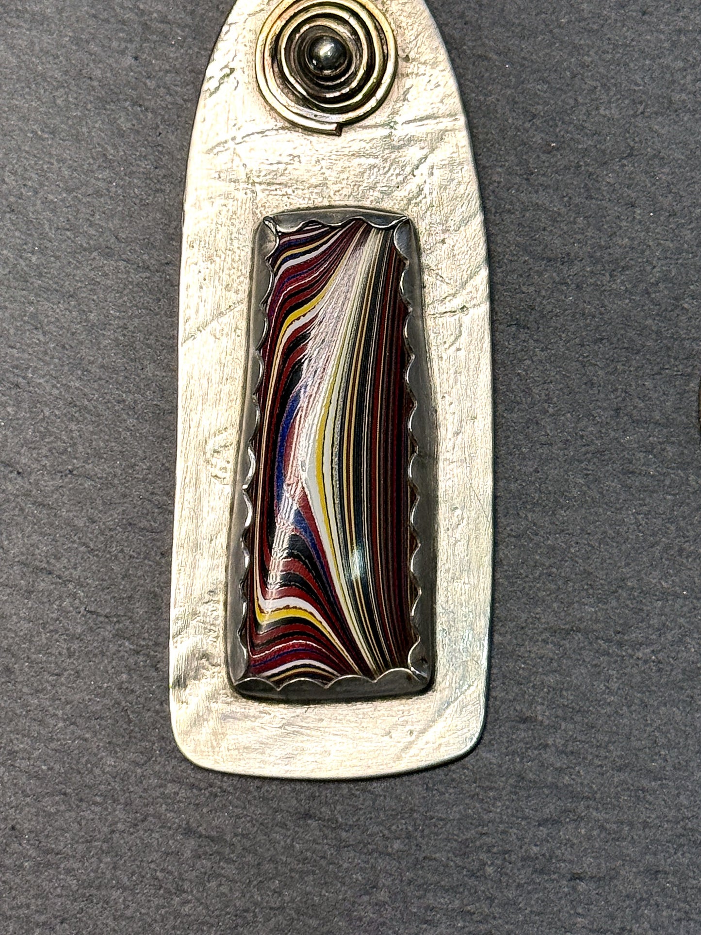 Sterling silver fordite pendant with brass-accent sun spiral and Detroit-agate inlay
