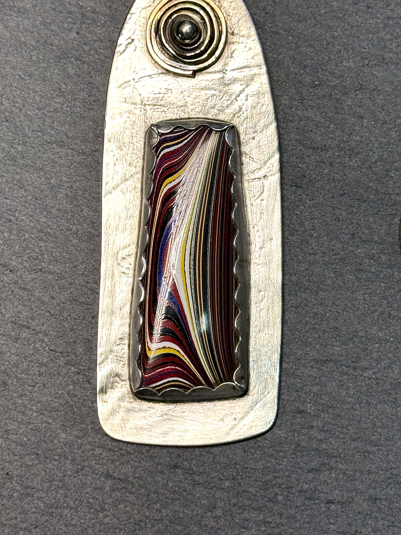 Sterling silver fordite pendant with brass-accent sun spiral and Detroit-agate inlay