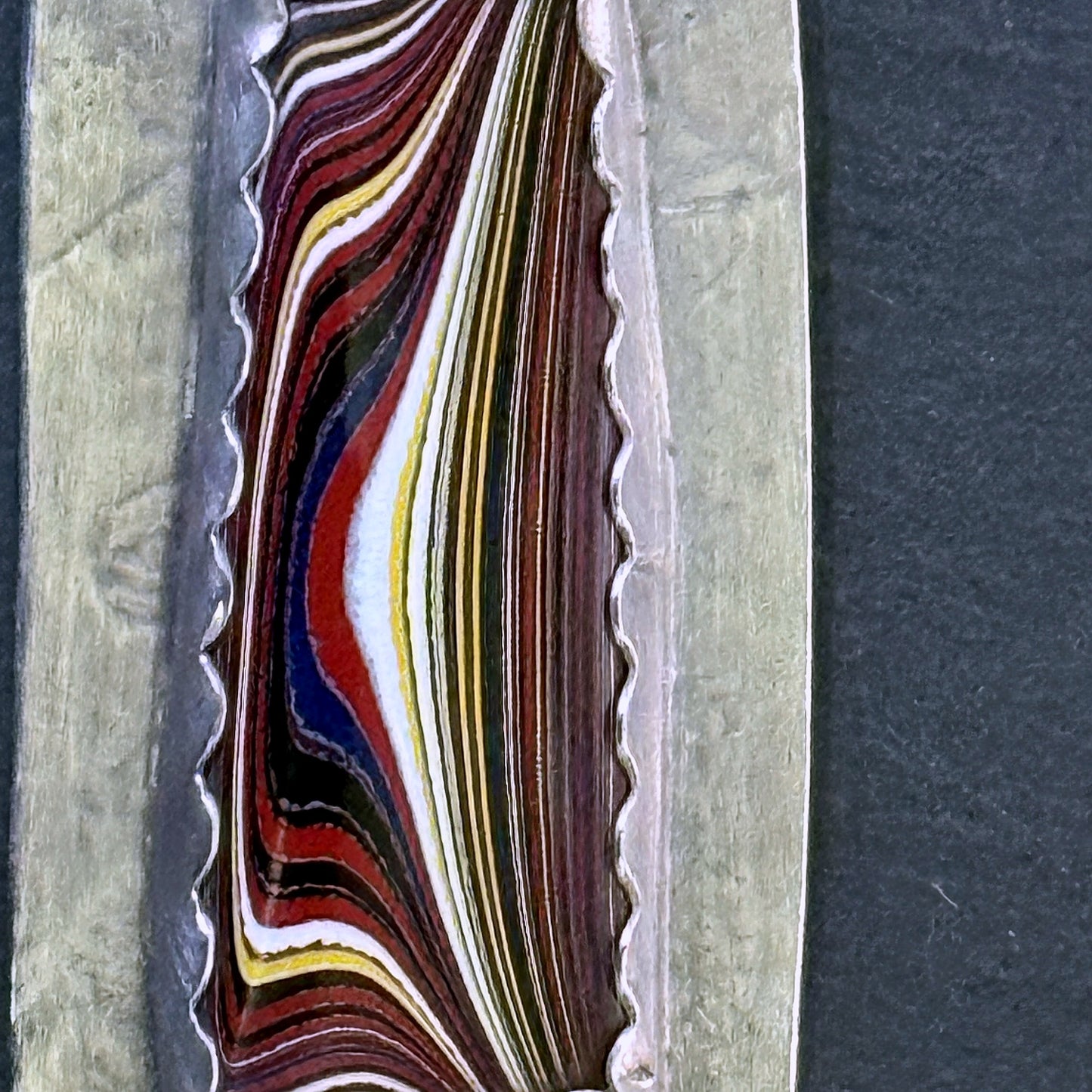 Macro of the Detroit-paint fordite layers in the pendant